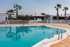 basen z białym płotem i palmami w obiekcie Villa Axular w mieście Playa Blanca