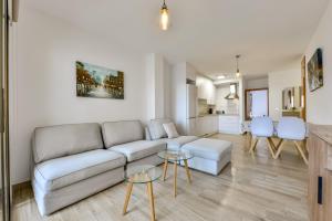 ein Wohnzimmer mit einem Sofa und einem Tisch in der Unterkunft Apartamento "Casa Auri" con Piscina, Wi-fi y Parking Gratis in Calpe