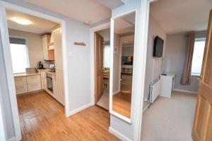 a kitchen with white cabinets and a mirror at Fellseeker in Keswick
