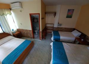 ein Hotelzimmer mit 2 Betten und einem Spiegel in der Unterkunft HOSTAL JANET STARLiNK in Puerto Villamil