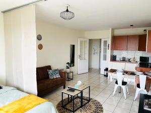 a living room and kitchen with a couch and a table at Spacieux studio sans vis à vis in Chelles