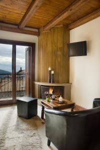 a living room with a fireplace and a table and chairs at Xenonas Iresioni in Arachova
