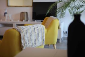 a yellow chair with a blanket on it in a living room at T3 tout confort PLAGE A 20 METRES in Saint-Cyr-sur-Mer