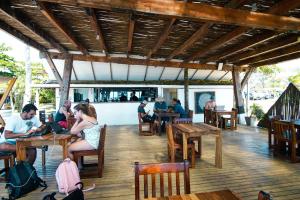 a group of people sitting at tables in a restaurant at Selina River Venao in Playa Venao