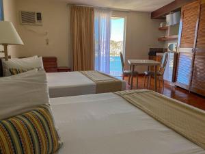 a hotel room with two beds and a view of the ocean at Alba Suites Acapulco in Acapulco