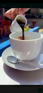 a person is pouring sauce into a cup of coffee at Hotel Luna Nueva in Colán