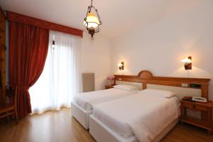 A bed or beds in a room at Olympic Turismo Antico Borgo Hotel