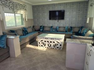 a living room with a couch and a tv at Villa Overlooking Beach - Private Swimming Pool! in Tangier