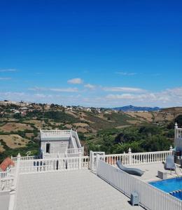 a white house with a swimming pool and a balcony at Villa Overlooking Beach - Private Swimming Pool! in Tangier