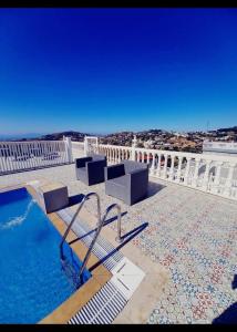a pool with a bench and chairs on top of a building at Villa Overlooking Beach - Private Swimming Pool! in Tangier