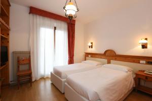 A bed or beds in a room at Olympic Turismo Antico Borgo Hotel