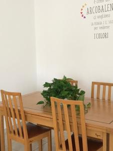 une table en bois avec des chaises et une plante en pot dans l'établissement MGM HOME AREZZO, à Arezzo