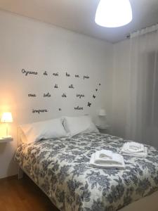 - une chambre dotée d'un lit avec des mots sur le mur dans l'établissement MGM HOME AREZZO, à Arezzo