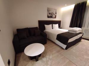 a bedroom with a bed and a couch and a table at Zoned II Kopaonik - Studio Njegomir in Kopaonik