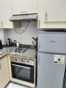 een keuken met een fornuis en een witte koelkast bij Ground Floor 2 Bedroom Apartment - City Centre Location - Optic Fibre Wifi in Tanger