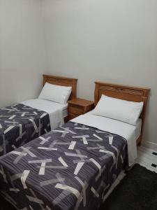 twee bedden naast elkaar in een kamer bij Ground Floor 2 Bedroom Apartment - City Centre Location - Optic Fibre Wifi in Tanger