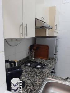 een aanrecht met een fornuis en een wastafel bij Ground Floor 2 Bedroom Apartment - City Centre Location - Optic Fibre Wifi in Tanger