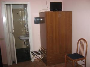 a bathroom with a wooden cabinet with a television on top at Hotel Ferraro in Rome