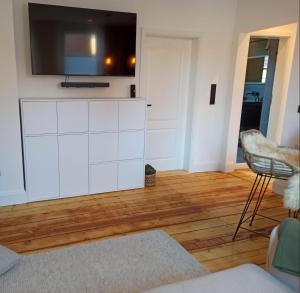 Ein Wohnzimmer mit einem Fernseher auf einem weißen Schrank. in der Unterkunft Redlinburg I in Quedlinburg
