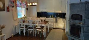 - une cuisine avec des placards blancs, une table et des chaises dans l'établissement Pulmustie 19as2 Huoneisto, à Ylivieska