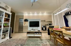 a living room with a television and a dining table at City EPI-CENTER in San Sebastián