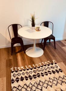 a white table and two chairs and a table and a rug at An der Uni Klinik Homburg, Neueröffnung Exklusiv neu renoviertes Apartment mit Küche und Badezimmer in Homburg