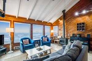 sala de estar con sofá, sillas y chimenea en Blue Sea Oceanfront Cottage, en Oceanside