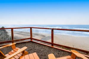 a balcony with chairs and a view of the beach at Blue Sea Oceanfront Cottage in Oceanside