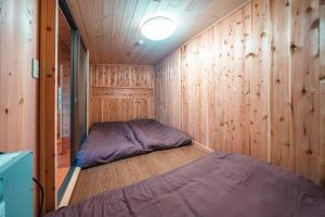 een kleine kamer met een bed in een houten muur bij Fukouji - Vacation STAY 07341v in Numata