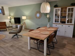 comedor con mesa de madera y sillas en Beach appartement Strandslag 129, en Julianadorp