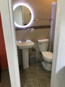La salle de bains est pourvue de toilettes, d'un lavabo et d'un miroir. dans l'établissement Casa alebrijes, à San Agustin de las Juntas