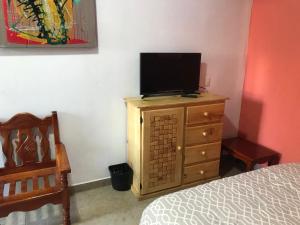 een slaapkamer met een televisie op een dressoir bij Casa alebrijes in San Agustin de las Juntas