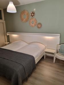 1 dormitorio con 1 cama y 2 espejos en la pared en Beach appartement Strandslag 129, en Julianadorp