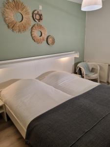 1 dormitorio con 1 cama con 3 espejos en la pared en Beach appartement Strandslag 129, en Julianadorp