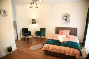 - une chambre avec un lit, deux chaises et une table dans l'établissement Aria Apartmani, à Podgorica