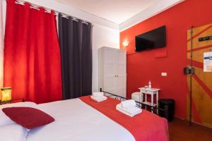フィレンツェにあるFirenze Rentals Uffiziの赤い壁のベッド付きの赤いベッドルーム