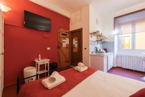 フィレンツェにあるFirenze Rentals Uffiziの赤い壁のベッドルーム(ベッド1台、テレビ付)