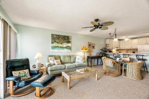 a living room with a couch and chairs and a kitchen at Sea Village #3-203 in Kailua-Kona