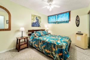 a bedroom with a bed and a ceiling fan at Sea Village #3-203 in Kailua-Kona +19 photos