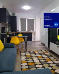 un soggiorno con divano blu e una cucina di Yellow House Luxury Berceni a Bucarest
