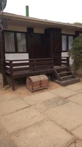 a building with a bench and a box in front of it at Cabaña 8 personas a pasos de la playa in El Quisco