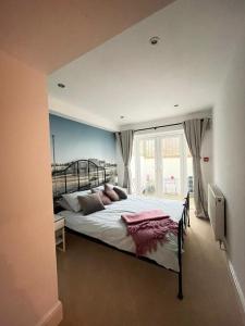 a large bed in a bedroom with a window at Beach Retreat, Stones Throw Away from Beach in Margate