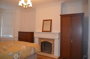 a bedroom with a bed and a fireplace at The Crandale Road House in Bath