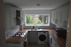 una cucina con lavandino, piano cottura e finestra di The Crandale Road House a Bath
