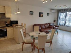 a kitchen and a living room with a table and chairs at Sun Coast Apartment in Sveti Vlas