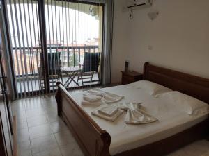 a bedroom with a bed with towels and a balcony at Sun Coast Apartment in Sveti Vlas +42 photos