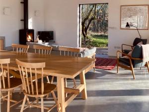 a living room with a wooden table and chairs at High Cogges Farm Holiday Cottages - The Cart Shed in Witney