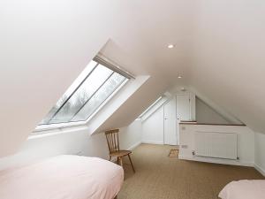 A bed or beds in a room at High Cogges Farm Holiday Cottages - The Cart Shed