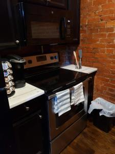 a kitchen with a stove top oven next to a brick wall at Fresh Modern Industrial split level in Cincinnati +17 photos