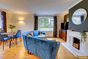 a living room with a blue couch and a fireplace at Kist Accommodates - Stylish Headingley Apartment - Parking - 500 mps WIFI in Meanwood